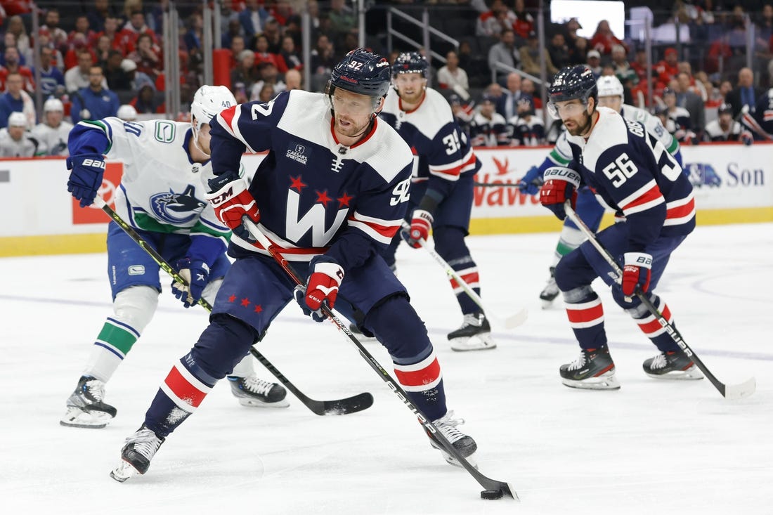 Oct 17, 2022; Washington, District of Columbia, USA; Washington Capitals center Evgeny Kuznetsov (92) skates with the puck as Vancouver Canucks center Elias Pettersson (40) chases in the first period at Capital One Arena. Mandatory Credit: Geoff Burke-USA TODAY Sports