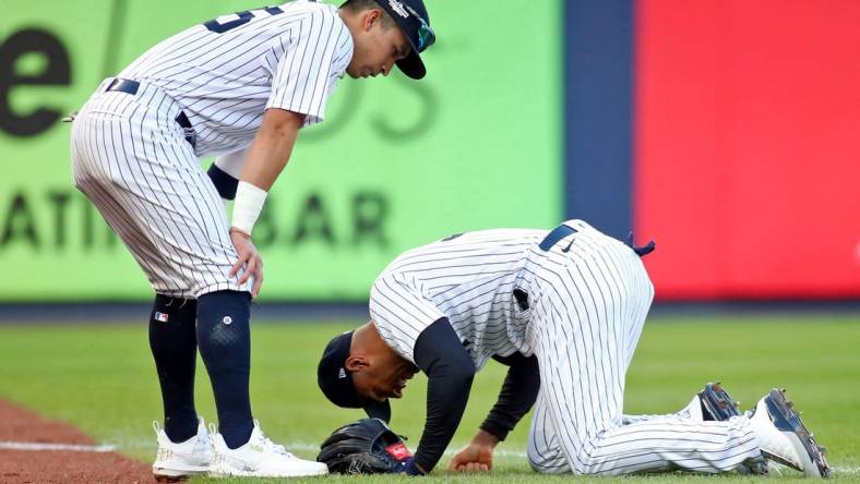 Oct 18, 2022; Bronx, New York, USA; New York Yankees left fielder Aaron Hicks (right) reacts after colliding with shortstop Oswaldo Cabrera (left) while trying to catch a ball hit by Cleveland Guardians left fielder Steven Kwan (not pictured) for a single against the Cleveland Guardians during the third inning in game five of the ALDS for the 2022 MLB Playoffs at Yankee Stadium. Mandatory Credit: Wendell Cruz-USA TODAY Sports