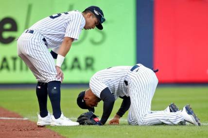 Oct 18, 2022; Bronx, New York, USA; New York Yankees left fielder Aaron Hicks (right) reacts after colliding with shortstop Oswaldo Cabrera (left) while trying to catch a ball hit by Cleveland Guardians left fielder Steven Kwan (not pictured) for a single against the Cleveland Guardians during the third inning in game five of the ALDS for the 2022 MLB Playoffs at Yankee Stadium. Mandatory Credit: Wendell Cruz-USA TODAY Sports