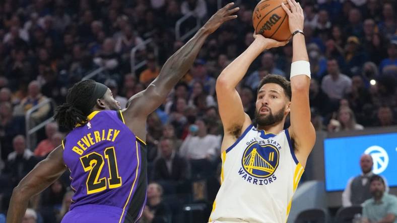 October 18, 2022; San Francisco, California, USA; Golden State Warriors guard Klay Thompson (11) shoots the basketball against Los Angeles Lakers guard Patrick Beverley (21) during the first quarter at Chase Center. Mandatory Credit: Kyle Terada-USA TODAY Sports