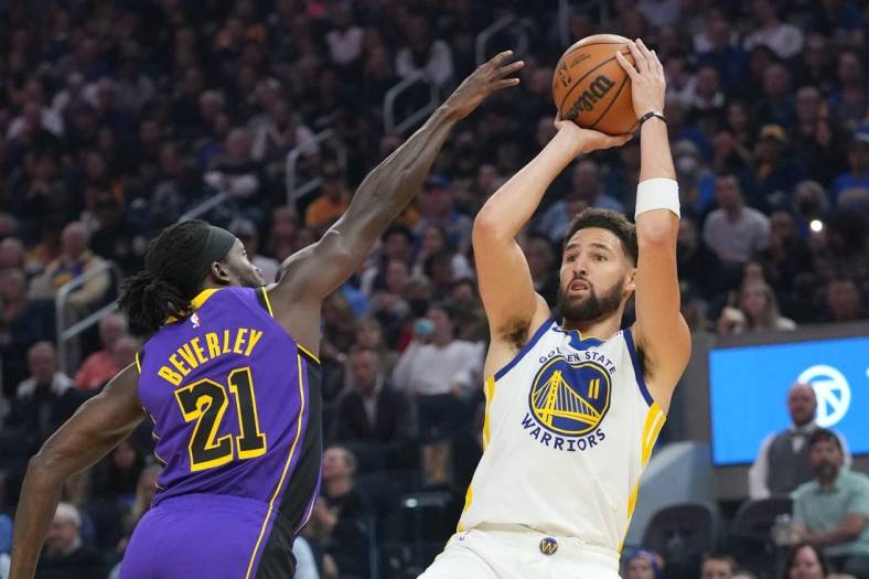 October 18, 2022; San Francisco, California, USA; Golden State Warriors guard Klay Thompson (11) shoots the basketball against Los Angeles Lakers guard Patrick Beverley (21) during the first quarter at Chase Center. Mandatory Credit: Kyle Terada-USA TODAY Sports