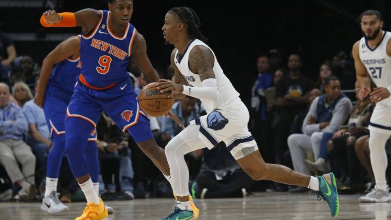 Oct 19, 2022; Memphis, Tennessee, USA; Memphis Grizzlies guard Ja Morant (12) dribbles as New York Knicks guard RJ Barrett (9) defends during the first half at FedExForum. Mandatory Credit: Petre Thomas-USA TODAY Sports