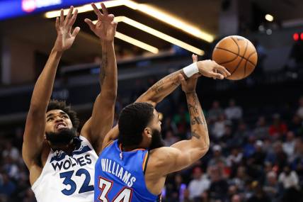 Oct 19, 2022; Minneapolis, Minnesota, USA; Oklahoma City Thunder forward Kenrich Williams (34) attempts a pass while Minnesota Timberwolves center Karl-Anthony Towns (32) defends during the second quarter at Target Center. Mandatory Credit: Matt Krohn-USA TODAY Sports