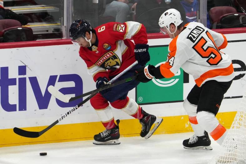 Oct 19, 2022; Sunrise, Florida, USA; Philadelphia Flyers defenseman Egor Zamula (54) and Florida Panthers center Colin White (6) battle for the puck during the third period at FLA Live Arena. Mandatory Credit: Jasen Vinlove-USA TODAY Sports