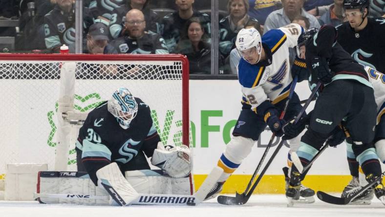 Oct 19, 2022; Seattle, Washington, USA; Seattle Kraken goalkeeper Martin Jones (30) stops a shot by St. Louis Blues forward Noel Acciari (52) during the first period at Climate Pledge Arena. Mandatory Credit: Stephen Brashear-USA TODAY Sports