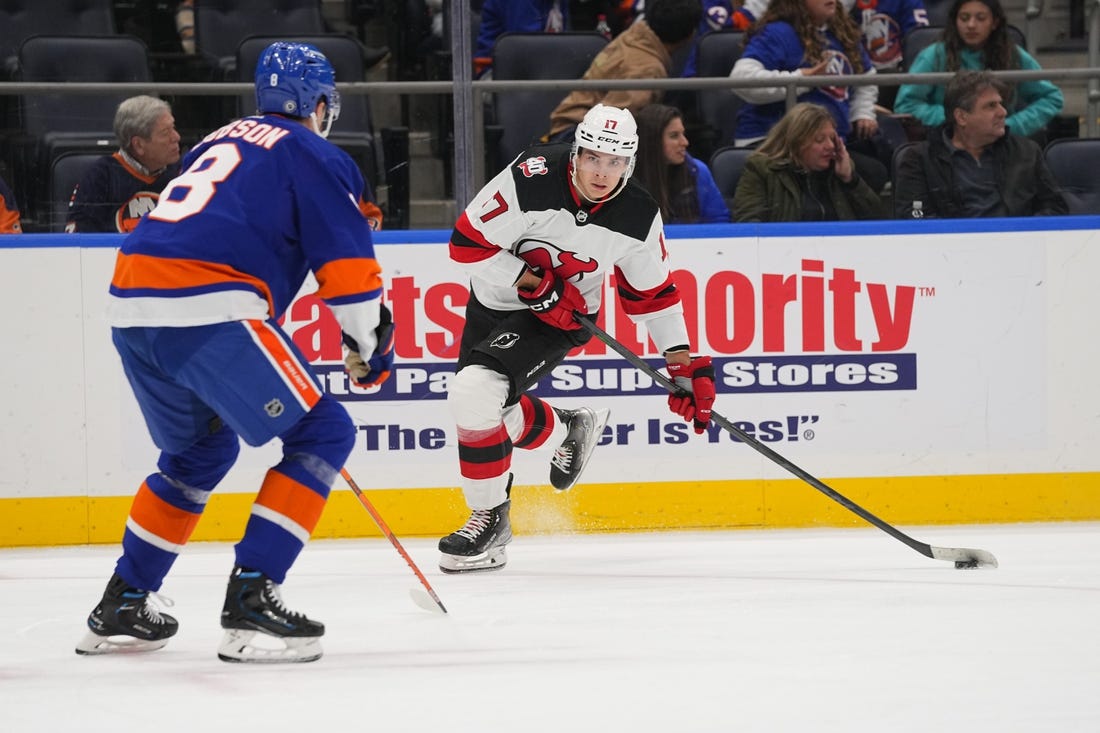 Oct 20, 2022; Elmont, New York, USA;  New Jersey Devils center Yegor Sharangovich (17) skates with the puck with New York Islanders defenseman Noah Dobson (8) defending during the first period at UBS Arena. Mandatory Credit: Gregory Fisher-USA TODAY Sports