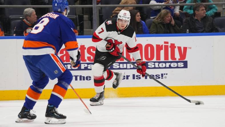 Oct 20, 2022; Elmont, New York, USA;  New Jersey Devils center Yegor Sharangovich (17) skates with the puck with New York Islanders defenseman Noah Dobson (8) defending during the first period at UBS Arena. Mandatory Credit: Gregory Fisher-USA TODAY Sports