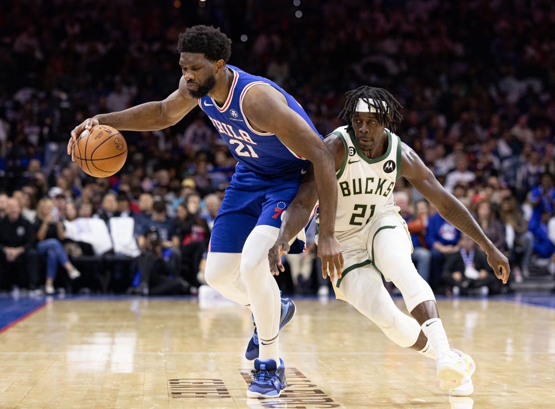 Oct 20, 2022; Philadelphia, Pennsylvania, USA; Philadelphia 76ers center Joel Embiid (21) is tripped up and fouled by Milwaukee Bucks guard Jrue Holiday (21) during the second quarter at Wells Fargo Center. Mandatory Credit: Bill Streicher-USA TODAY Sports