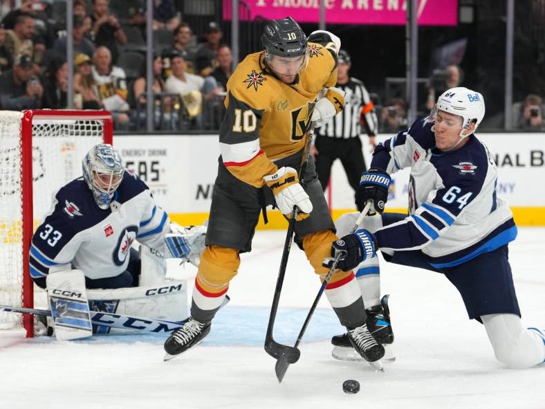 Oct 20, 2022; Las Vegas, Nevada, USA; Winnipeg Jets defenseman Logan Stanley (64) defends against a pass attempt by Vegas Golden Knights center Nicolas Roy (10) in front of Winnipeg Jets goaltender David Rittich (33) during the second period at T-Mobile Arena. Mandatory Credit: Stephen R. Sylvanie-USA TODAY Sports