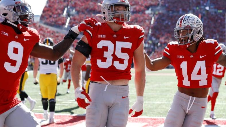 Oct 22, 2022; Columbus, Ohio, USA;  Ohio State Buckeyes linebacker Tommy Eichenberg (35) celebrates his interception return for a touchdown with safety Ronnie Hickman (14) and defensive end Zach Harrison (9) during the second quarter against the Iowa Hawkeyes at Ohio Stadium. Mandatory Credit: Joseph Maiorana-USA TODAY Sports