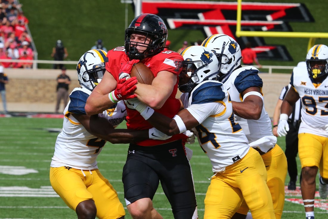 Oct 22, 2022; Lubbock, Texas, USA;  Texas Tech Red Raiders tight end Mason Tharp (80) is tackled by West Virginia Mountaineers defensive safety Marcis Floyd (24), defensive corner back Rashad Ajayi (4) and defensive linebacker Jasir Cox (7) in the first half at Jones AT&T Stadium and Cody Campbell Field. Mandatory Credit: Michael C. Johnson-USA TODAY Sports