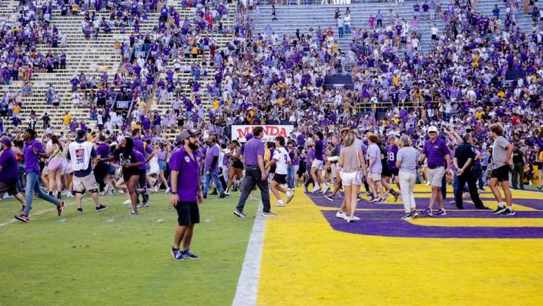 Oct 22, 2022; Baton Rouge, Louisiana, USA; LSU Tigers fans storm the field after LSU defeated the Mississippi Rebels at Tiger Stadium. Mandatory Credit: Stephen Lew-USA TODAY Sports