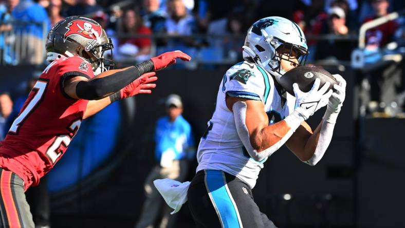 Oct 23, 2022; Charlotte, North Carolina, USA; Carolina Panthers tight end Tommy Tremble (82) catches a touchdown as Tampa Bay Buccaneers cornerback Zyon McCollum (27) defends in the fourth quarter at Bank of America Stadium. Mandatory Credit: Bob Donnan-USA TODAY Sports