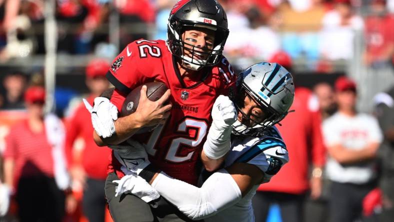 Oct 23, 2022; Charlotte, North Carolina, USA; Tampa Bay Buccaneers quarterback Tom Brady (12) is tackled by Carolina Panthers linebacker Frankie Luvu (49) in the third quarter at Bank of America Stadium. Mandatory Credit: Bob Donnan-USA TODAY Sports