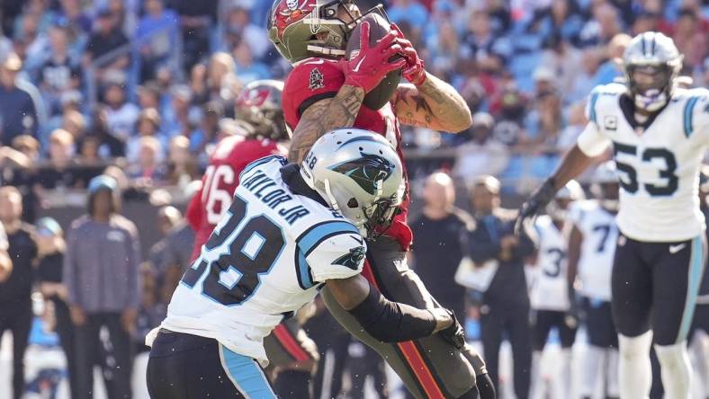 Oct 23, 2022; Charlotte, North Carolina, USA; Tampa Bay Buccaneers wide receiver Mike Evans (13) is hit as he makes a catch by Carolina Panthers cornerback Keith Taylor Jr. (28) during the second half at Bank of America Stadium. Mandatory Credit: Jim Dedmon-USA TODAY Sports