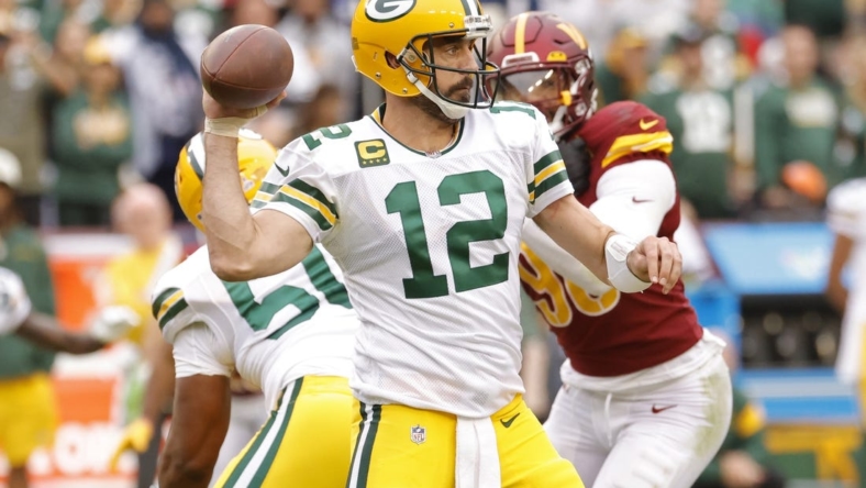 Oct 23, 2022; Landover, Maryland, USA; Green Bay Packers quarterback Aaron Rodgers (12) passes the ball as Washington Commanders defensive end Montez Sweat (90) chases during the fourth quarter at FedExField. Mandatory Credit: Geoff Burke-USA TODAY Sports