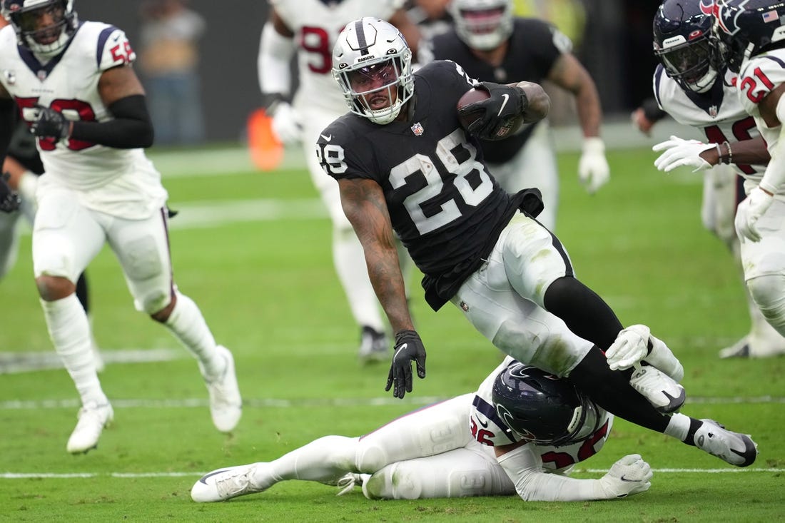 Oct 23, 2022; Paradise, Nevada, USA; Houston Texans safety Jonathan Owens (36) tackles Las Vegas Raiders running back Josh Jacobs (28) in the first half at Allegiant Stadium. Mandatory Credit: Stephen R. Sylvanie-USA TODAY Sports