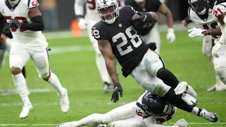 Oct 23, 2022; Paradise, Nevada, USA; Houston Texans safety Jonathan Owens (36) tackles Las Vegas Raiders running back Josh Jacobs (28) in the first half at Allegiant Stadium. Mandatory Credit: Stephen R. Sylvanie-USA TODAY Sports