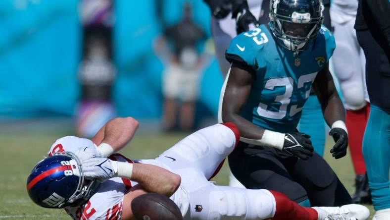 New York Giants tight end Daniel Bellinger (82) grabs his face after a tackle by Jacksonville Jaguars linebacker Devin Lloyd (33) which took Bellinger out of the game with an injury to his face late in the second quarter. The Jacksonville Jaguars hosted the New York Giants at TIAA Bank Field in Jacksonville, FL Sunday, October 23, 2022. The Jaguars trailed at the half 11 to 13. [Bob Self/Florida Times-Union]

Jki 102322 Hsfb Bs Jaguars Vs Giants 46