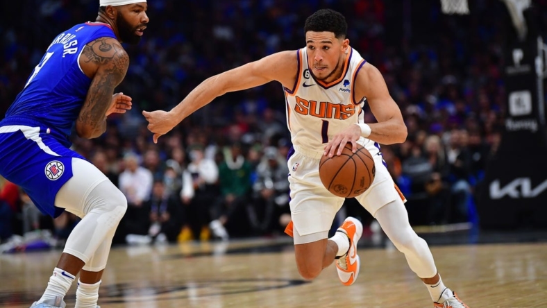 Oct 23, 2022; Los Angeles, California, USA; Phoenix Suns guard Devin Booker (1) moves the ball against Los Angeles Clippers forward Marcus Morris Sr. (8) during the first half at Crypto.com Arena. Mandatory Credit: Gary A. Vasquez-USA TODAY Sports