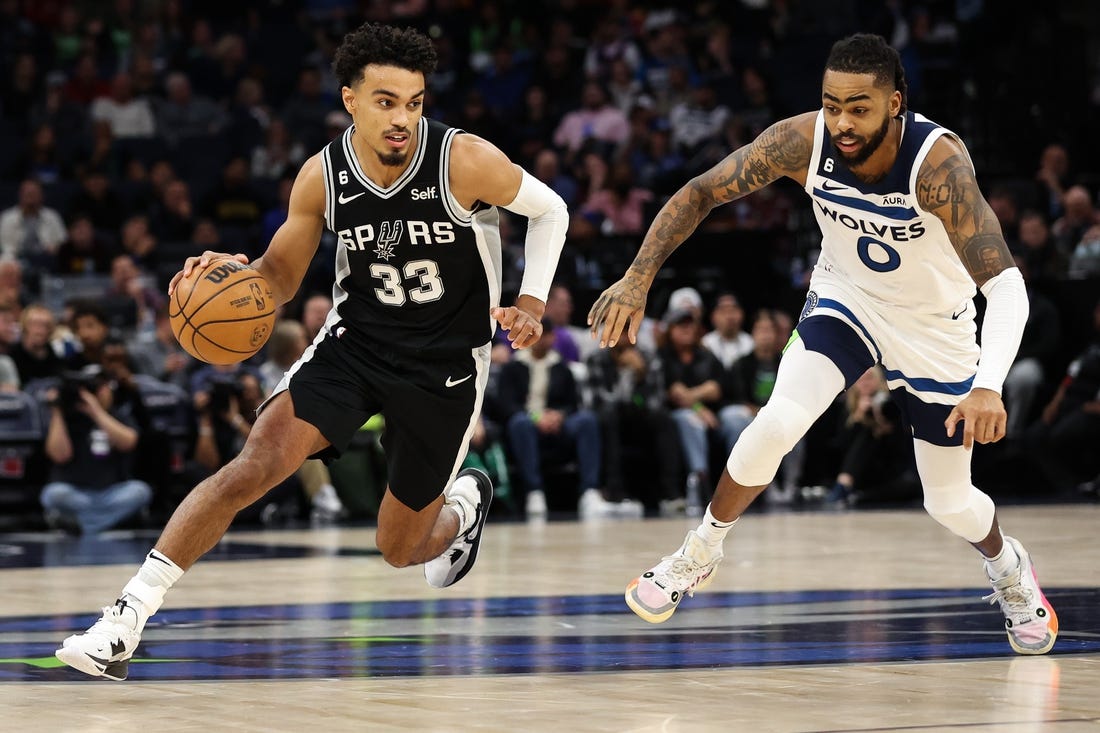 Oct 24, 2022; Minneapolis, Minnesota, USA; San Antonio Spurs guard Tre Jones (33) dribbles while Minnesota Timberwolves guard D'Angelo Russell (0) defends during the second quarter at Target Center. Mandatory Credit: Matt Krohn-USA TODAY Sports