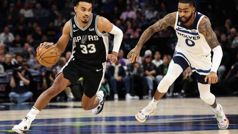 Oct 24, 2022; Minneapolis, Minnesota, USA; San Antonio Spurs guard Tre Jones (33) dribbles while Minnesota Timberwolves guard D'Angelo Russell (0) defends during the second quarter at Target Center. Mandatory Credit: Matt Krohn-USA TODAY Sports