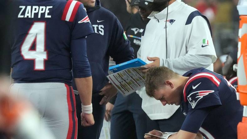 Patriot coaches Joe Judge and Matt Patricia confer as they talk with QN Bailey Zappe as QB Mac Jones studies his play list on his wrist after Jones was replaced by Zappe during the 2nd quarter.

15 Pats Bears 102422 Bb