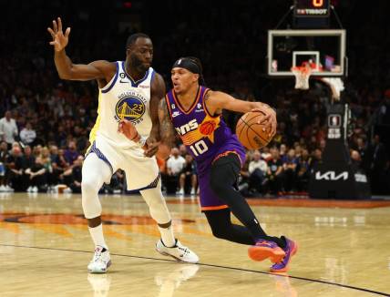 Oct 25, 2022; Phoenix, Arizona, USA; Phoenix Suns guard Damion Lee (10) moves the ball against Golden State Warriors forward Draymond Green (23) in the first half at Footprint Center. Mandatory Credit: Mark J. Rebilas-USA TODAY Sports