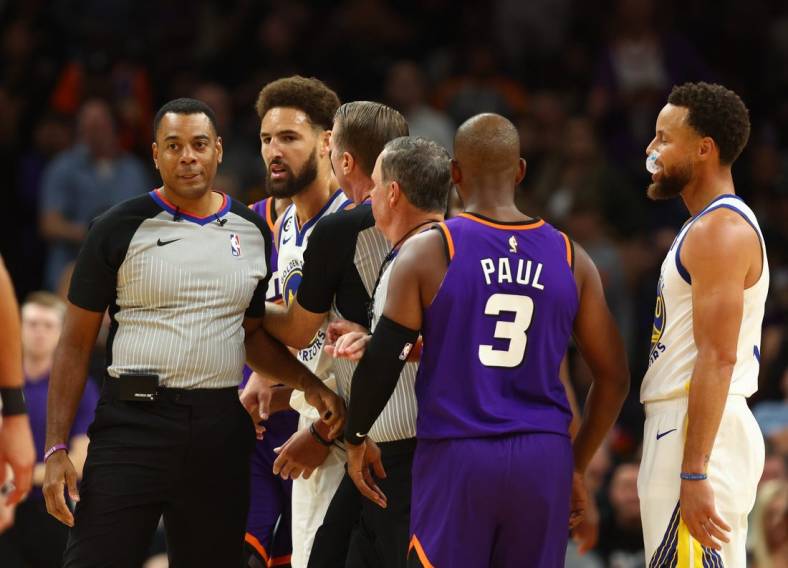 Oct 25, 2022; Phoenix, Arizona, USA; Golden State Warriors guard Klay Thompson (second from left) is held back by referees after being ejected from the game against the Phoenix Suns in the second half at Footprint Center. Mandatory Credit: Mark J. Rebilas-USA TODAY Sports