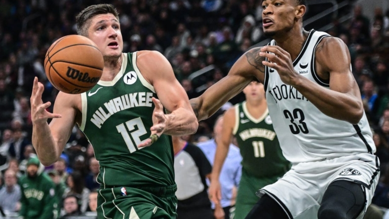 Oct 26, 2022; Milwaukee, Wisconsin, USA; Milwaukee Bucks guard Grayson Allen (12) drives to the basket against Brooklyn Nets center Nicolas Claxton (33) in the second quarter at Fiserv Forum. Mandatory Credit: Benny Sieu-USA TODAY Sports