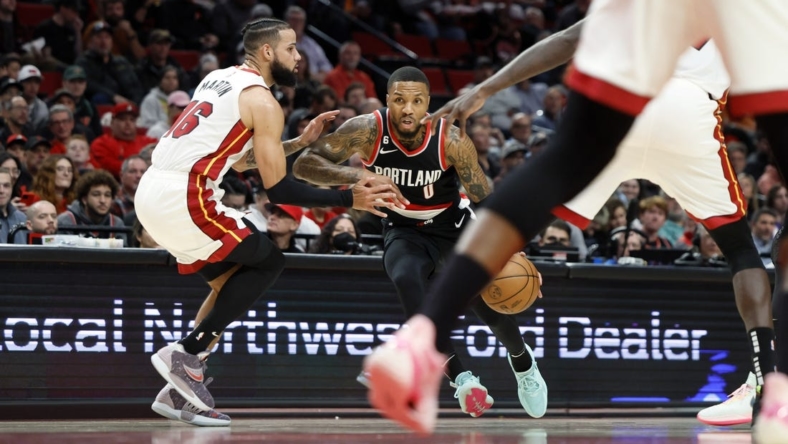 Oct 26, 2022; Portland, Oregon, USA; Portland Trail Blazers point guard Damian Lillard (0) dribbles the ball while defended by  Miami Heat small forward Caleb Martin (16) during the first half at Moda Center. Mandatory Credit: Soobum Im-USA TODAY Sports