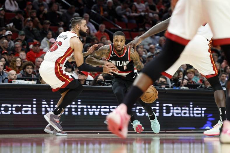 Oct 26, 2022; Portland, Oregon, USA; Portland Trail Blazers point guard Damian Lillard (0) dribbles the ball while defended by  Miami Heat small forward Caleb Martin (16) during the first half at Moda Center. Mandatory Credit: Soobum Im-USA TODAY Sports