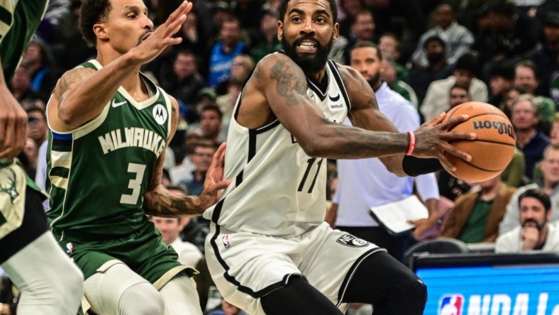 Oct 26, 2022; Milwaukee, Wisconsin, USA; Brooklyn Nets guard Kyrie Irving (11) drives to the basket against Milwaukee Bucks guard George Hill (3) in the fourth quarter at Fiserv Forum. Mandatory Credit: Benny Sieu-USA TODAY Sports