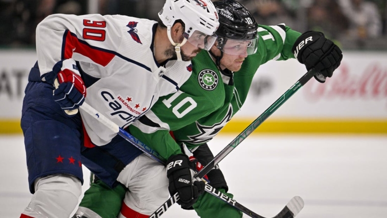 Oct 27, 2022; Dallas, Texas, USA; Washington Capitals left wing Marcus Johansson (90) and Dallas Stars center Ty Dellandrea (10) battle for position during the second period at the American Airlines Center. Mandatory Credit: Jerome Miron-USA TODAY Sports