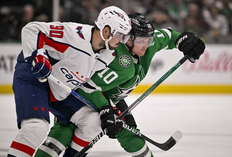 Oct 27, 2022; Dallas, Texas, USA; Washington Capitals left wing Marcus Johansson (90) and Dallas Stars center Ty Dellandrea (10) battle for position during the second period at the American Airlines Center. Mandatory Credit: Jerome Miron-USA TODAY Sports