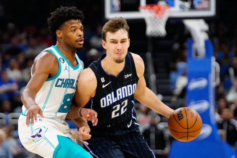 Oct 28, 2022; Orlando, Florida, USA; Orlando Magic forward Franz Wagner (22) dribbles past Charlotte Hornets guard Dennis Smith Jr. (8) during the second quarter at Amway Center. Mandatory Credit: Rich Storry-USA TODAY Sports
