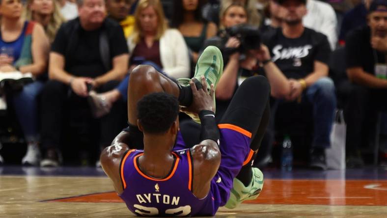 Oct 28, 2022; Phoenix, Arizona, USA; Phoenix Suns center Deandre Ayton (22) grabs his ankle after suffering an injury against the New Orleans Pelicans during the first half at Footprint Center. Mandatory Credit: Mark J. Rebilas-USA TODAY Sports