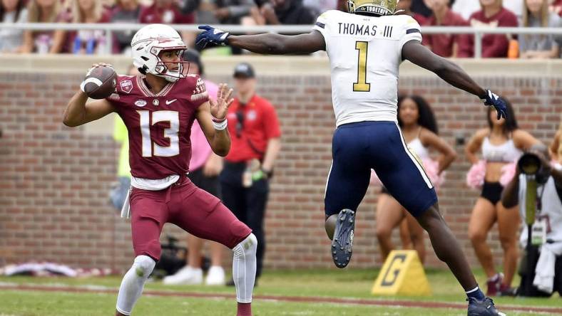 Oct 29, 2022; Tallahassee, Florida, USA; Florida State Seminoles quarterback Jordan Travis (13) is pressured by Georgia Tech Yellow Jackets linebacker Charlie Thomas (1)  during the first half at Doak S. Campbell Stadium. Mandatory Credit: Melina Myers-USA TODAY Sports