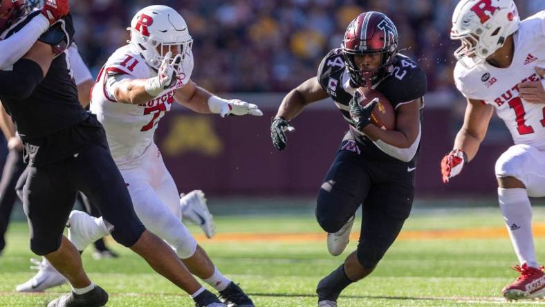 Oct 29, 2022; Minneapolis, Minnesota, USA; Minnesota Golden Gophers running back Mohamed Ibrahim (24) evades Rutgers Scarlet Knights defensive lineman Aaron Lewis (71) in the first quarter at Huntington Bank Stadium. Mandatory Credit: Matt Blewett-USA TODAY Sports