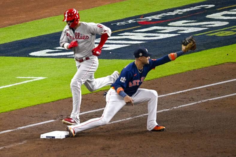 Oct 29, 2022; Houston, Texas, USA; Houston Astros first baseman Yuli Gurriel (10) puts out Philadelphia Phillies right fielder Nick Castellanos (8) at first base during the fourth inning during game two of the 2022 World Series at Minute Maid Park. Mandatory Credit: Jerome Miron-USA TODAY Sports
