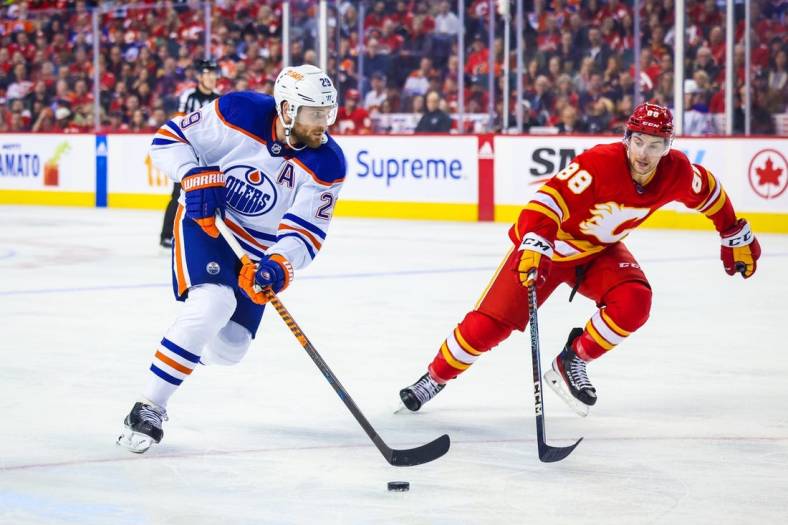 Oct 29, 2022; Calgary, Alberta, CAN; Edmonton Oilers center Leon Draisaitl (29) and Calgary Flames left wing Andrew Mangiapane (88) battle for the puck during the second period at Scotiabank Saddledome. Mandatory Credit: Sergei Belski-USA TODAY Sports