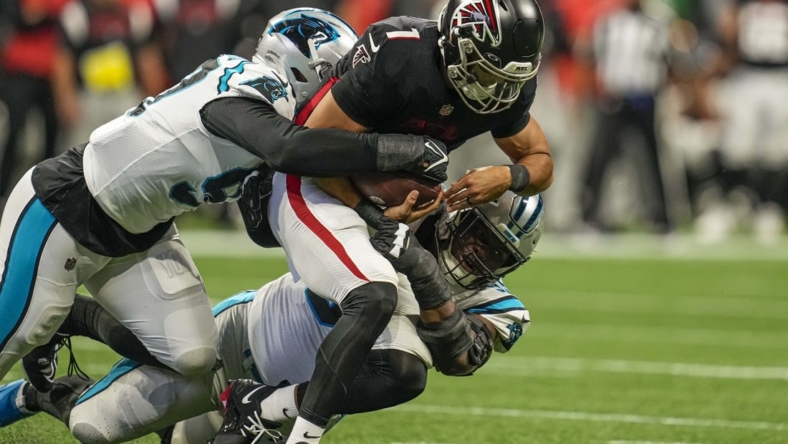 Oct 30, 2022; Atlanta, Georgia, USA; Atlanta Falcons quarterback Marcus Mariota (1) is tackled for a loss by Carolina Panthers defensive end Yetur Gross-Matos (97) and defensive tackle Derrick Brown (95) during the first quarter at Mercedes-Benz Stadium. Mandatory Credit: Dale Zanine-USA TODAY Sports