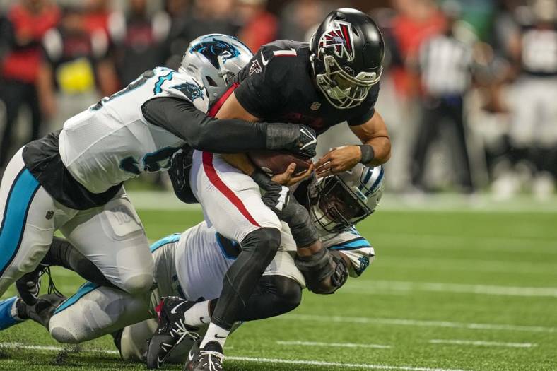 Oct 30, 2022; Atlanta, Georgia, USA; Atlanta Falcons quarterback Marcus Mariota (1) is tackled for a loss by Carolina Panthers defensive end Yetur Gross-Matos (97) and defensive tackle Derrick Brown (95) during the first quarter at Mercedes-Benz Stadium. Mandatory Credit: Dale Zanine-USA TODAY Sports