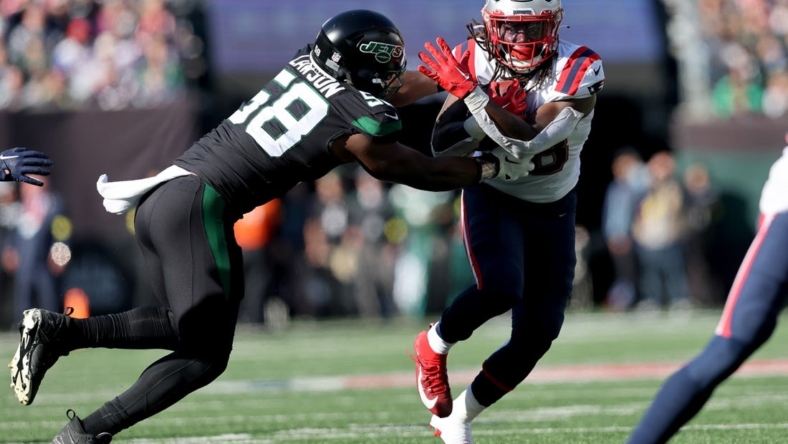 Oct 30, 2022; East Rutherford, New Jersey, USA; New England Patriots running back Rhamondre Stevenson (38) runs with the ball against New York Jets defensive end Carl Lawson (58) during the second quarter at MetLife Stadium. Mandatory Credit: Brad Penner-USA TODAY Sports