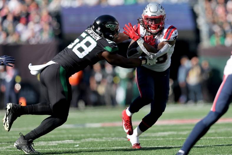 Oct 30, 2022; East Rutherford, New Jersey, USA; New England Patriots running back Rhamondre Stevenson (38) runs with the ball against New York Jets defensive end Carl Lawson (58) during the second quarter at MetLife Stadium. Mandatory Credit: Brad Penner-USA TODAY Sports