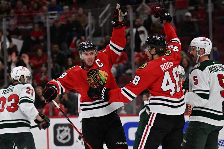 Oct 30, 2022; Chicago, Illinois, USA;  Chicago Blackhawks forward Jonathan Toews (19) celebrates with defenseman Filip Roos (48) after scoring a goal in the second period against the Minnesota Wild at the United Center. Mandatory Credit: Jamie Sabau-USA TODAY Sports