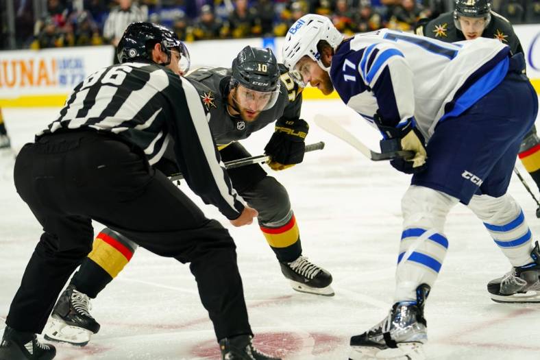 Oct 30, 2022; Las Vegas, Nevada, USA; Vegas Golden Knights center Nicolas Roy (10) and Winnipeg Jets center Adam Lowry (17) face off during the second period at T-Mobile Arena. Mandatory Credit: Lucas Peltier-USA TODAY Sports