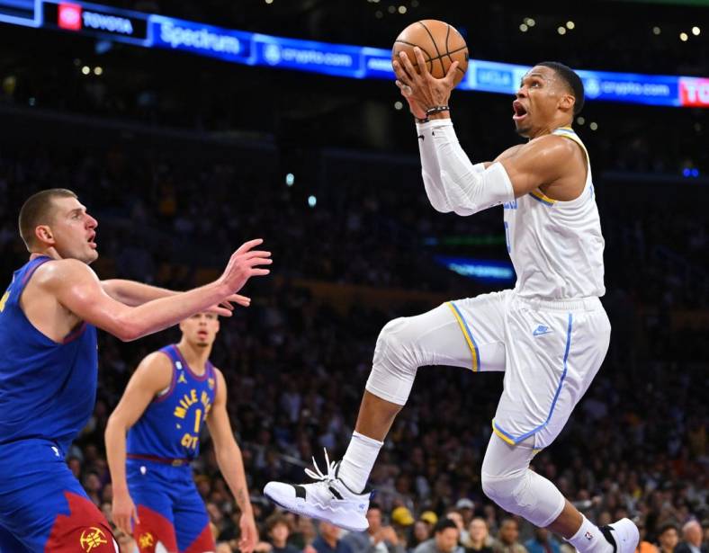 Oct 30, 2022; Los Angeles, California, USA;  Los Angeles Lakers guard Russell Westbrook (0) is defended by Denver Nuggets center Nikola Jokic (15) as he drives to the basket in the second half at Crypto.com Arena. Mandatory Credit: Jayne Kamin-Oncea-USA TODAY Sports