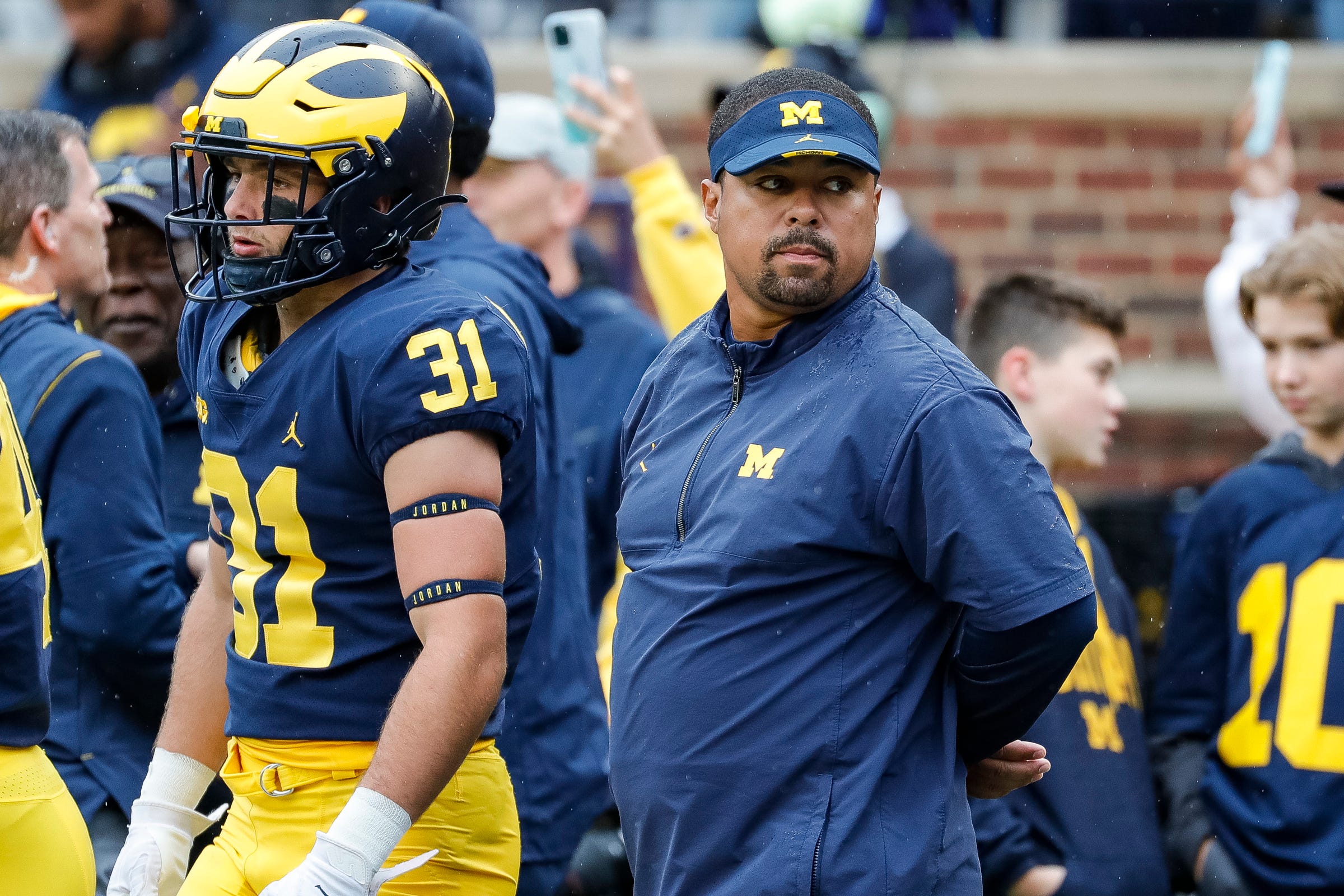 Former Michigan legend and current running backs coach Mike Hart carted off sideline with apparent seizure