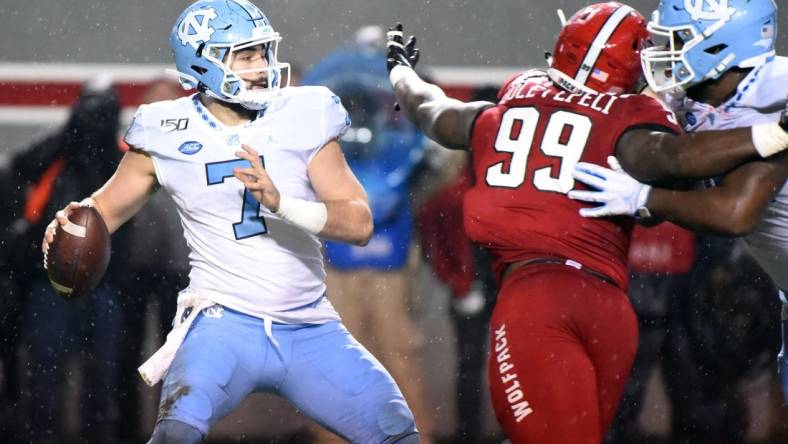 Nov 30, 2019; Raleigh, NC, USA; North Carolina Tar Heels quarterback Sam Howell (7) drops back to pass as North Carolina State Wolfpack defensive end Joseph Boletepeli (99) rushes during the first half at Carter-Finley Stadium. Mandatory Credit: Rob Kinnan-USA TODAY Sports